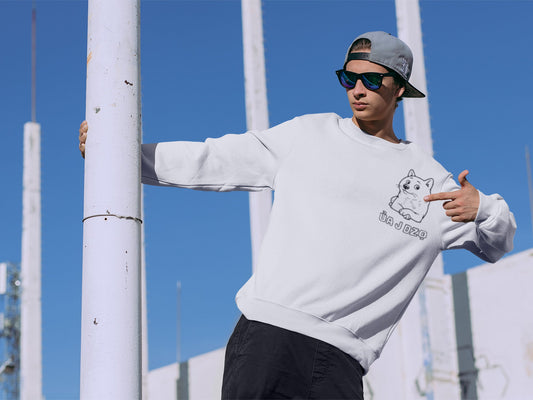 Trendy young man wearing a white crewneck with cute cartoon Shiba Inu dog with playful text, posing confidently outdoors. Perfect cozy streetwear for teens and young adults who love minimal, kawaii-inspired graphic apparel and unique sweatshirt designs.