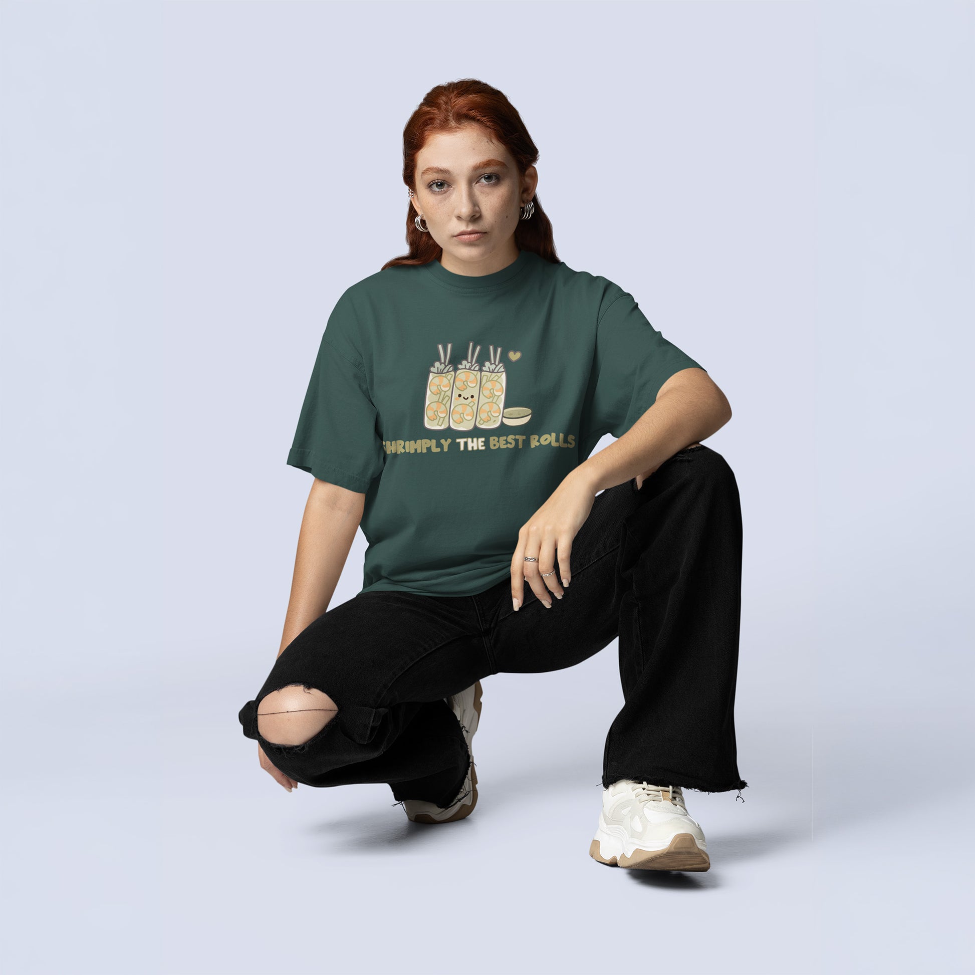 Female wearing a cute oversized shrimp spring roll graphic tee in blue spruce, styled with ripped black jeans for trendy teen and young adult streetwear fashion.
