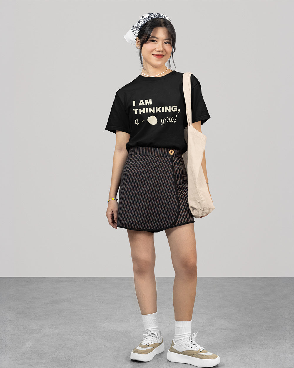 Full body view of female model wearing black cute bao bun graphic t-shirt with casual youthful streetwear style.