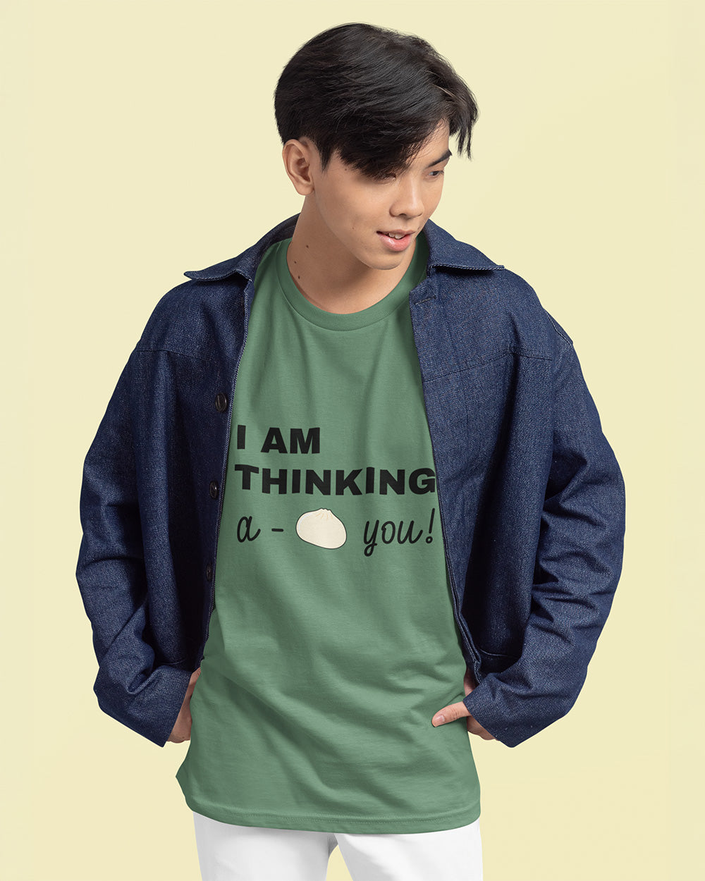 Male model wearing light green bao bun graphic tee layered with denim jacket for trendy youth fashion.