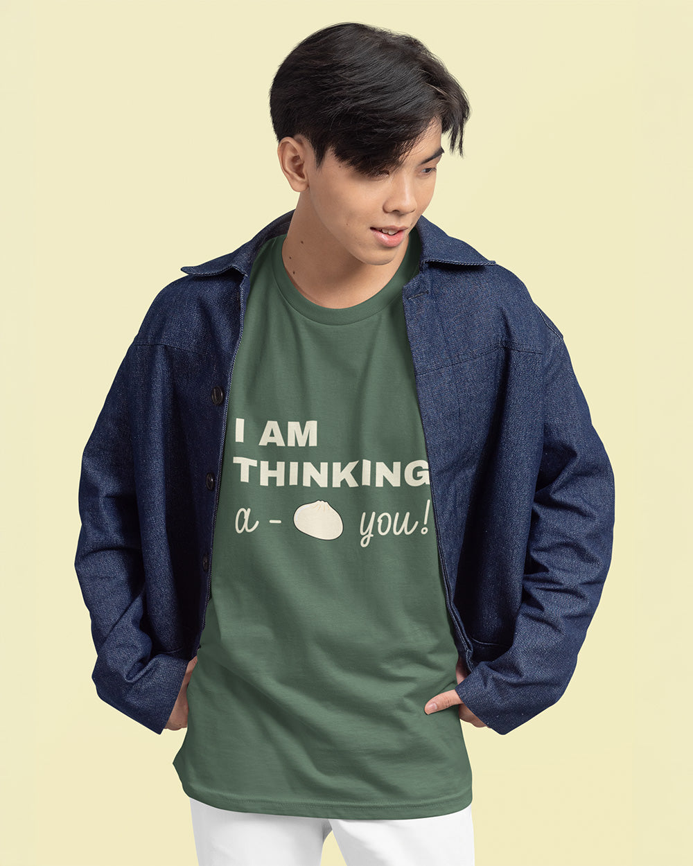 Male model wearing blue spruce bao bun graphic tee layered with denim jacket for trendy youth fashion.