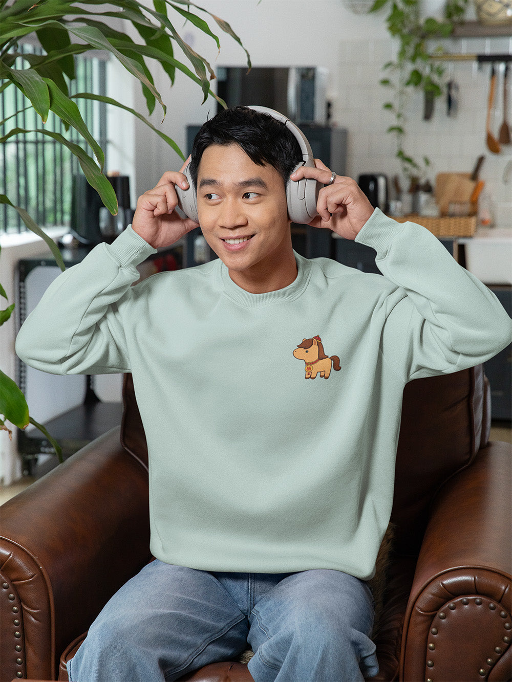 Model wearing agave green oversized crewneck sweatshirt with cute horse design, soft kawaii casual fashion for young adults and teens.