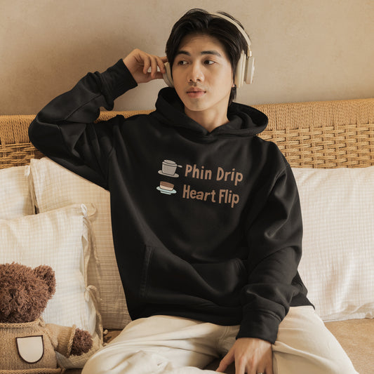 Person wearing a black hoodie with text, sitting on a couch, listen to music with a teddy bear.